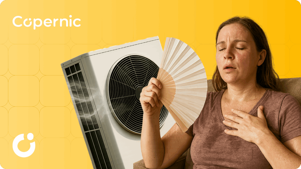 Kobieta siedząca na fotelu, spocona przez wysoką temperaturę, wachlująca się. Za kobietą pompa ciepła powietrze-powietrze